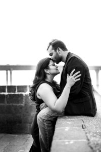 Man In Black Coat Sitting While Kissing Woman photo