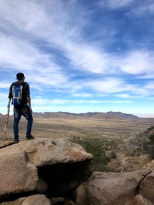 Man Wearing Backpack Standing On Stone photo