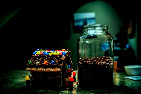Gingerbread House Near Clear Glass Jar Filled With Candies