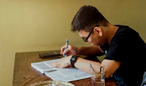 Man In Black Shirt Sitting And Writing