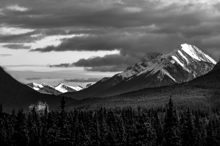 Grayscale Photography Of Snow Covered Mountain Under Cloudy Sky photo