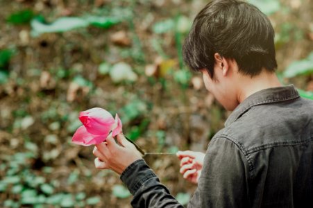 Man In Black Denim Jean Holding Pink Flower photo