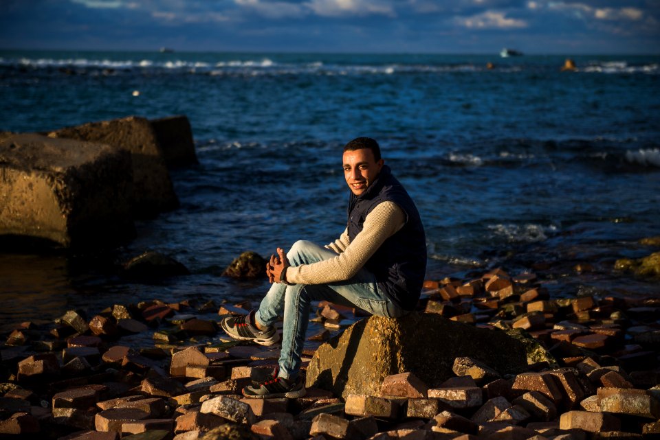 Man Sitting On Stone Under The Blue Sky