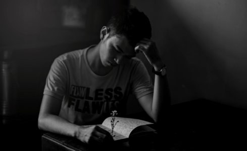 Grayscale Photography Of Man In Shirt Reading Notebook photo