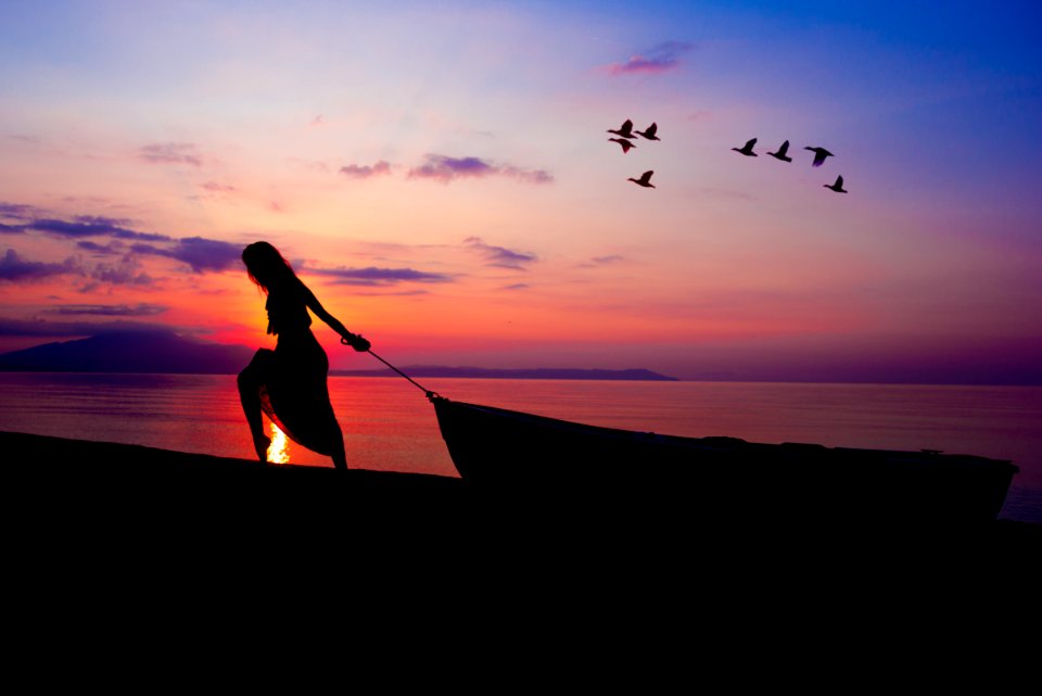 Silhouette On Person Towing Canoe