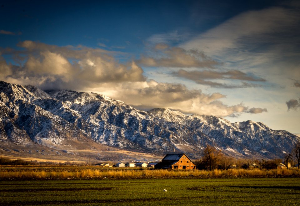 House Near Lawn Field And Mountain Cliff