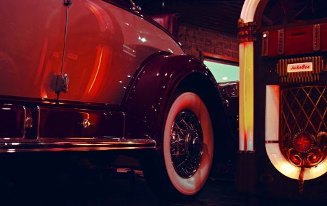 Lighted Jukebox Beside White And Brown Car photo