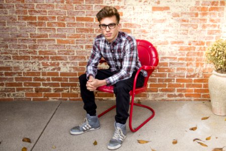 Man In Plaid Long-Sleeved Shirt And Black Pants Sitting On Red Chair photo