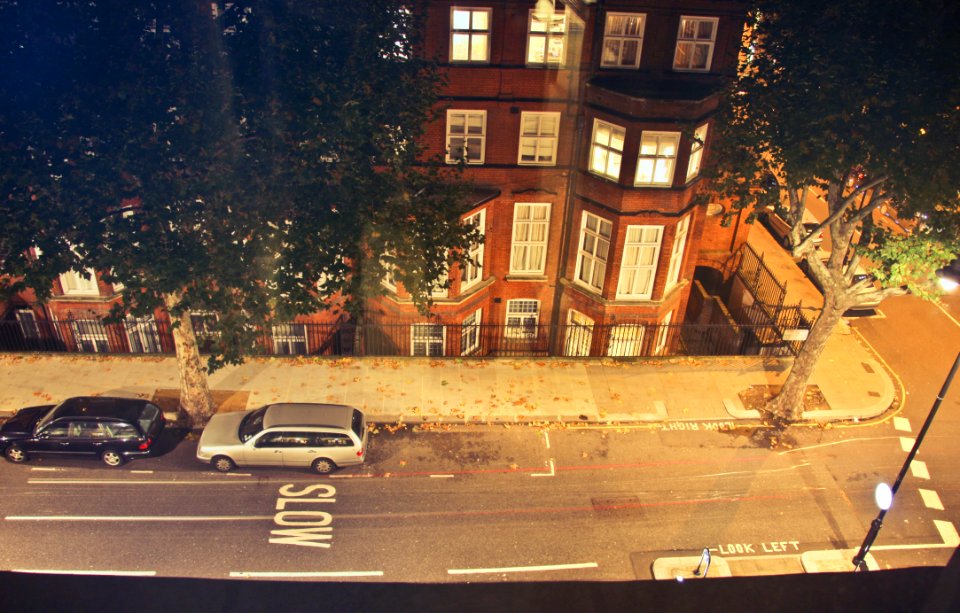 Two Cars Parked Near Brown Concrete Building During Nighttime