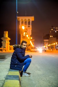 Man In Black Zip-up Hoodie Near White Building photo