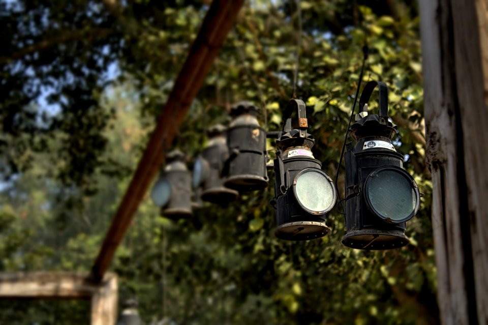 Black Metal Lanterns Hanged In Brown Wooden Frame