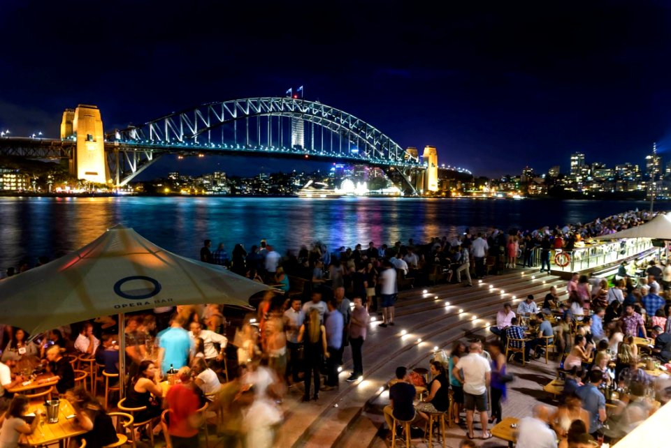 People Sitting And Standing Near Bridge During Nighttime