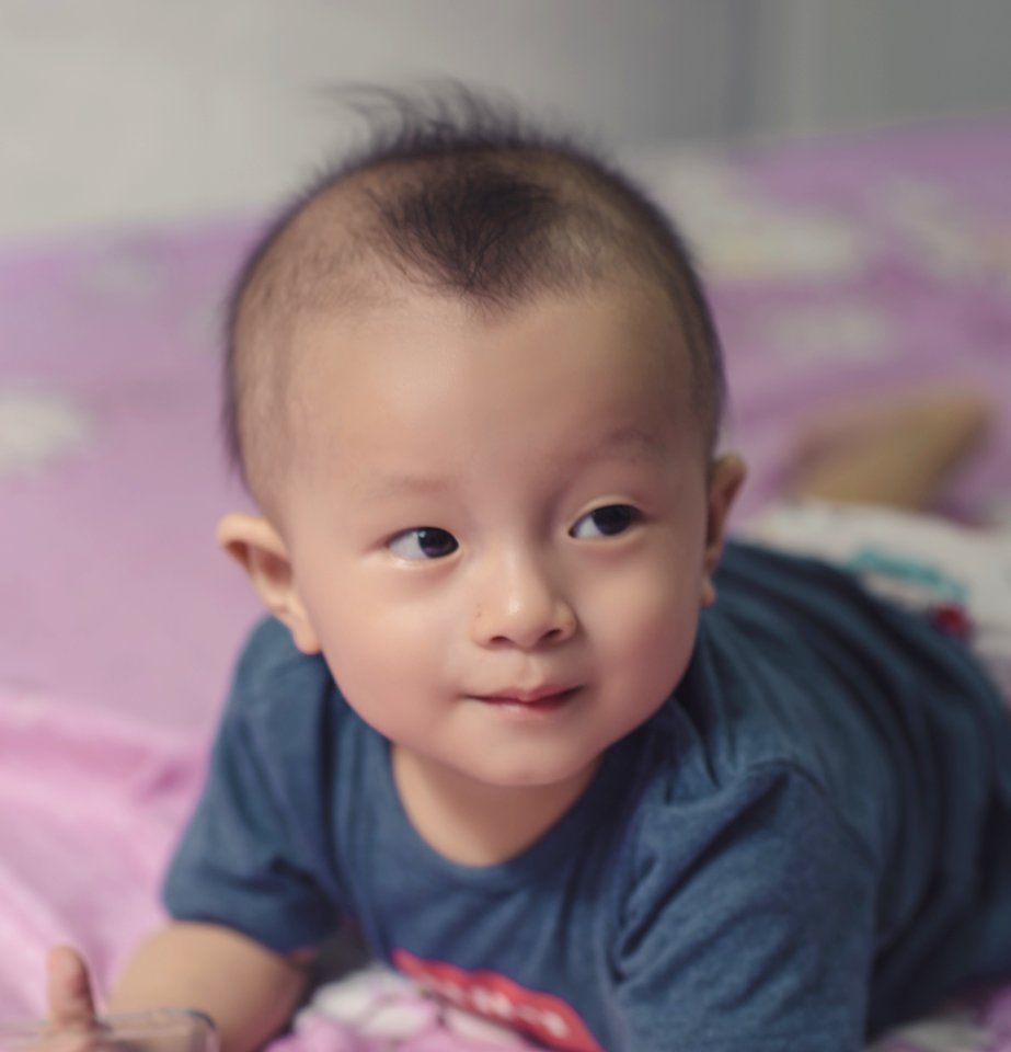 Photography Of Cute Baby Laying On The Bed photo