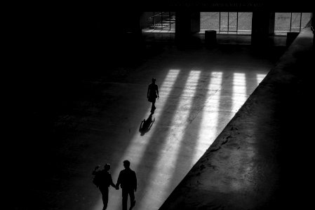 Grayscale Photo Of Three Men Walking Inside Building photo