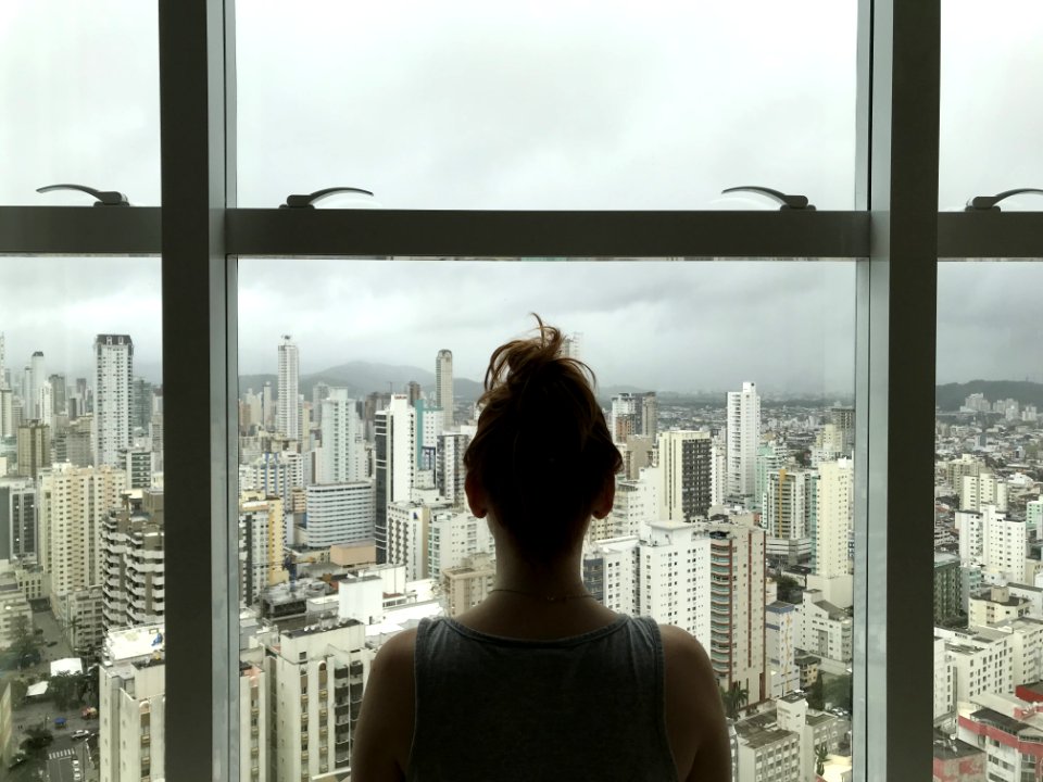 Woman Standing Near Glass Window