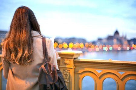 Woman Wearing Trench Coat And Black Leather Backpack photo