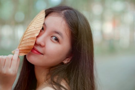 Photo Of A Woman Holding A Dry Leaf