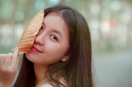 Photo Of A Woman Holding A Dry Leaf photo