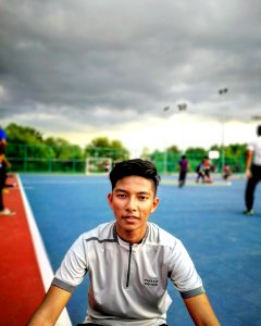 Tilt Lens Photography Of Man Sitting Near Soccer Field During Cloudy Day