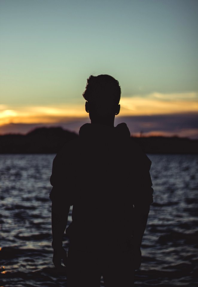 Silhouette Photo Of Person Near Body Of Water