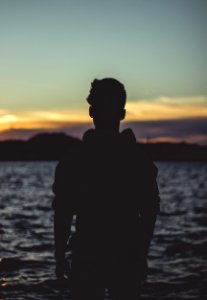 Silhouette Photo Of Person Near Body Of Water photo