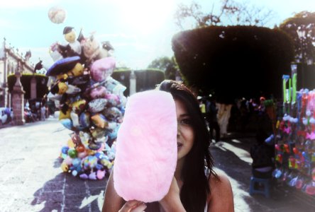 Woman Holding Cotton Candy With Balloons In Background