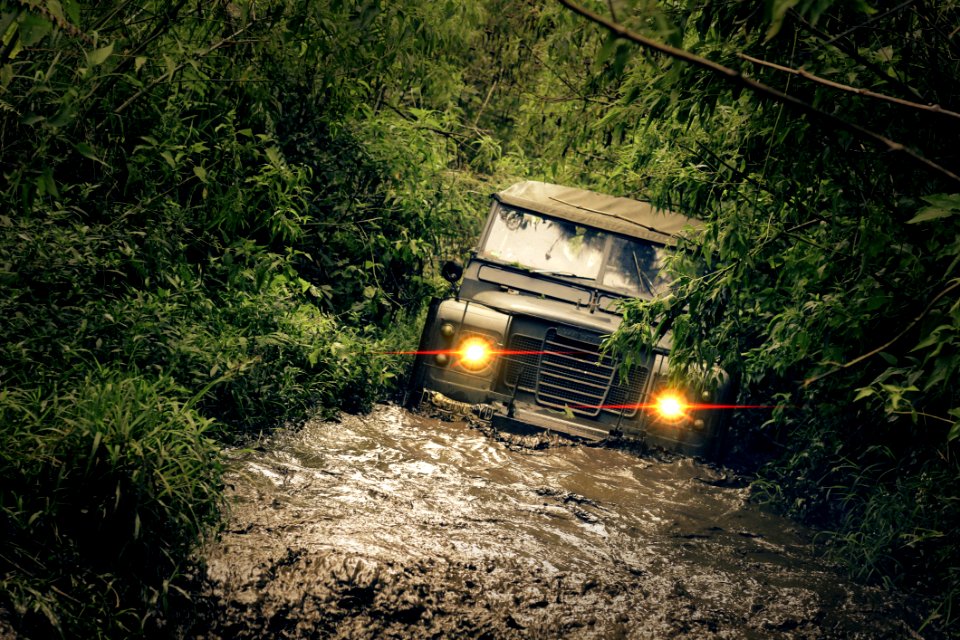 Green Car Running Of Flooded Road