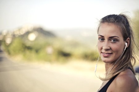 Woman Wearing Black Tank Top And White Earbuds photo