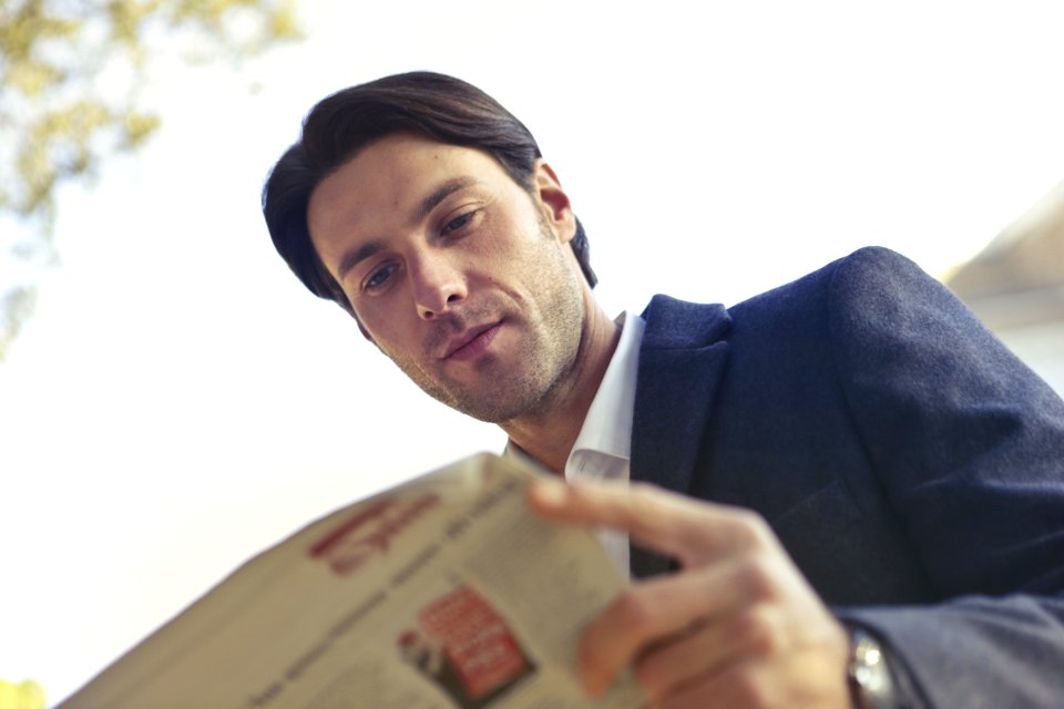 Low Angle Shot Of Man Reading Newspaper photo