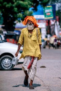 Man Walking On Street Carrying Metal Bucket photo