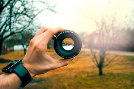 Photography Of Person Holding Black Camera Lens photo