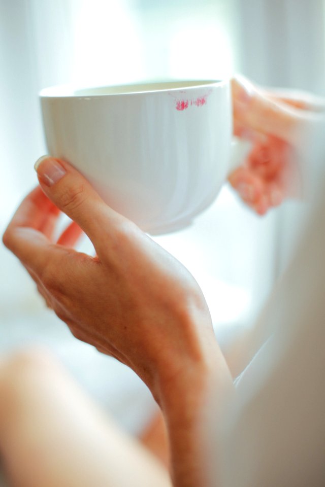 Person Holding White Ceramic Teacup