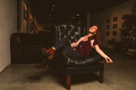 Woman In Maroon Scoop-neck Shirt Sitting On Black Leather Sofa Chair photo