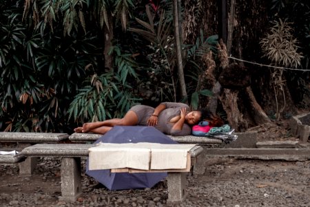 Woman In Gray Dress Lying On Bench photo