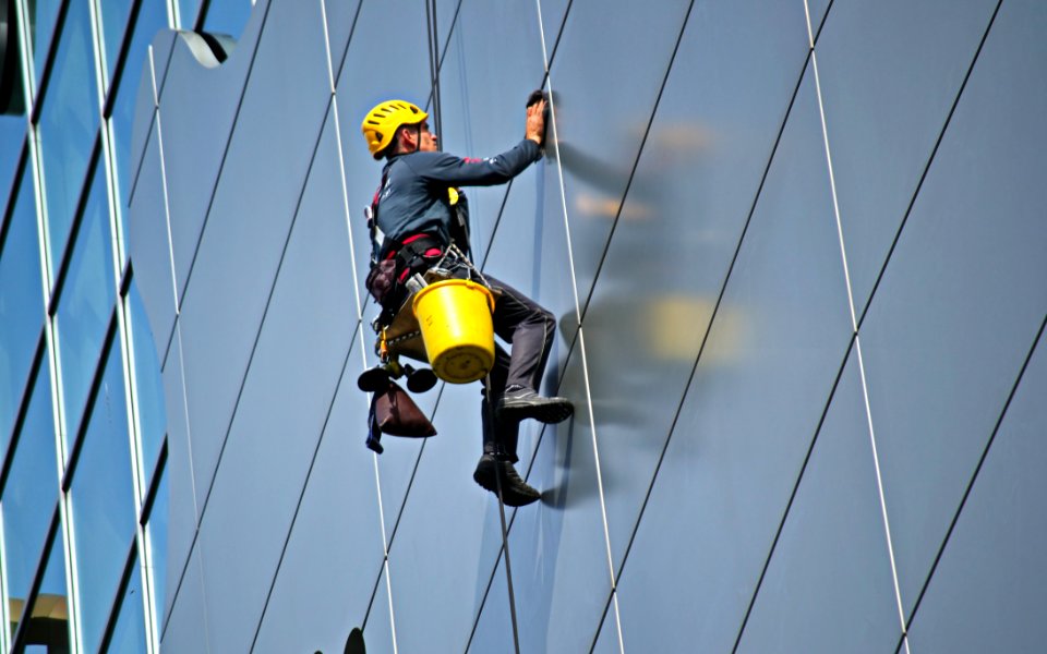 Man Cleaning The Glass Of Building