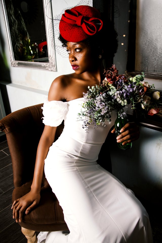 Woman Wearing White Off-shoulder Bodycon Dress Holding Flower Arrangement In Vase photo