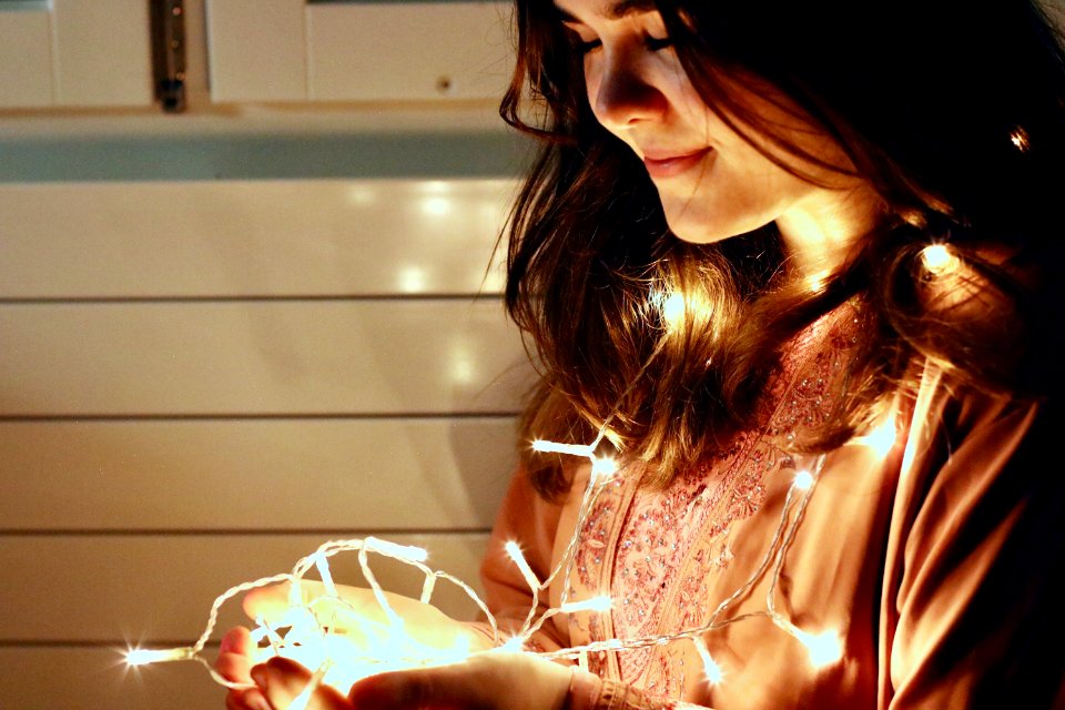 Woman Holding Lighted String Light