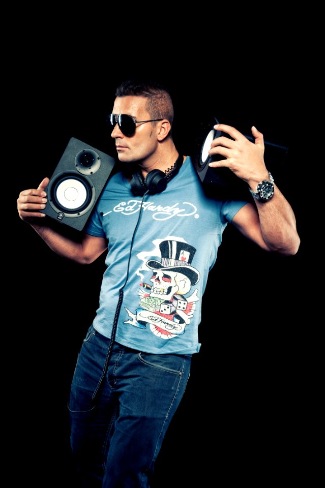 Black Haired Man Wearing Blue Printed Shirt Holding Speakers