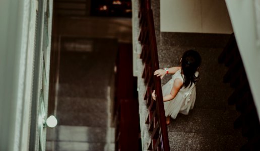 Girl In White Dress Standing In Front Of Railings photo