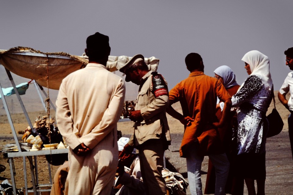 Group Of People On Desert Beside Brown Tent