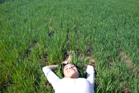 Woman Laying On Field Of Green Grass