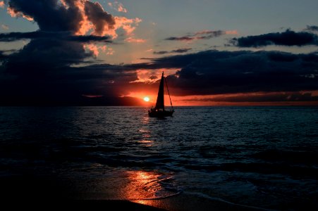 Silhouette Of Sailboat On Body Of Water During Sunset photo