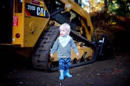 Baby Standing Near The CAT Skid Loader