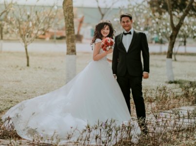 Woman Wearing White Wedding Ball Beside Man Wearing Black Notch-lapel Suit On Pathway Near The Green Grass Field