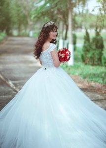 Woman In White Wedding Dress Holding Red Bouquet photo