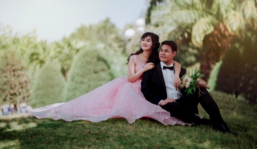 Nuptial Photo Of Man In Black Formal Suit And Woman In Pink Gown photo