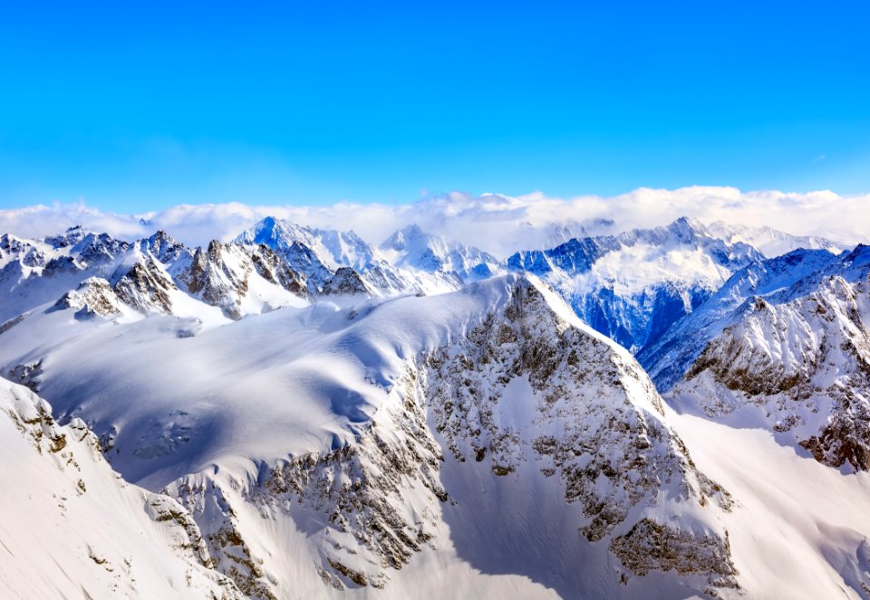 Areal Photography Of Snow Coated Mountains Under Clear Blue Sky