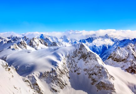 Areal Photography Of Snow Coated Mountains Under Clear Blue Sky photo