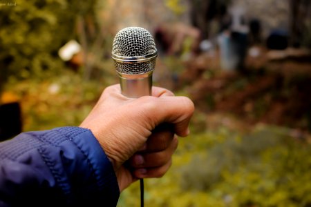 Person Holding Grey Corded Microphone In Selective Focus Photography Photo Taken