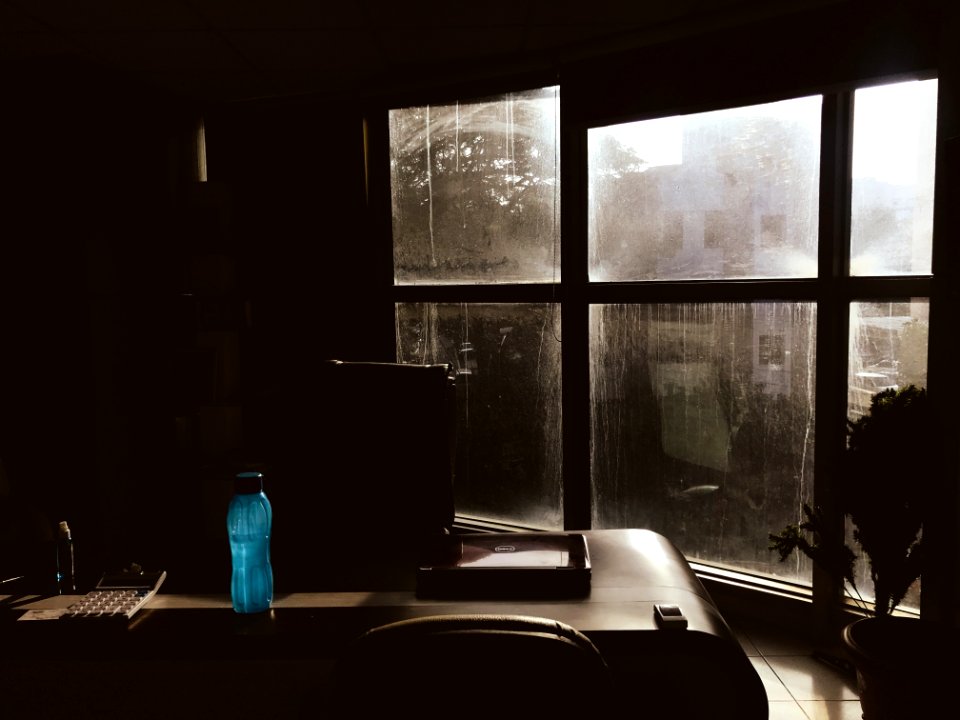 Blue Plastic Tumbler On Wooden Table Beside Chair In Room